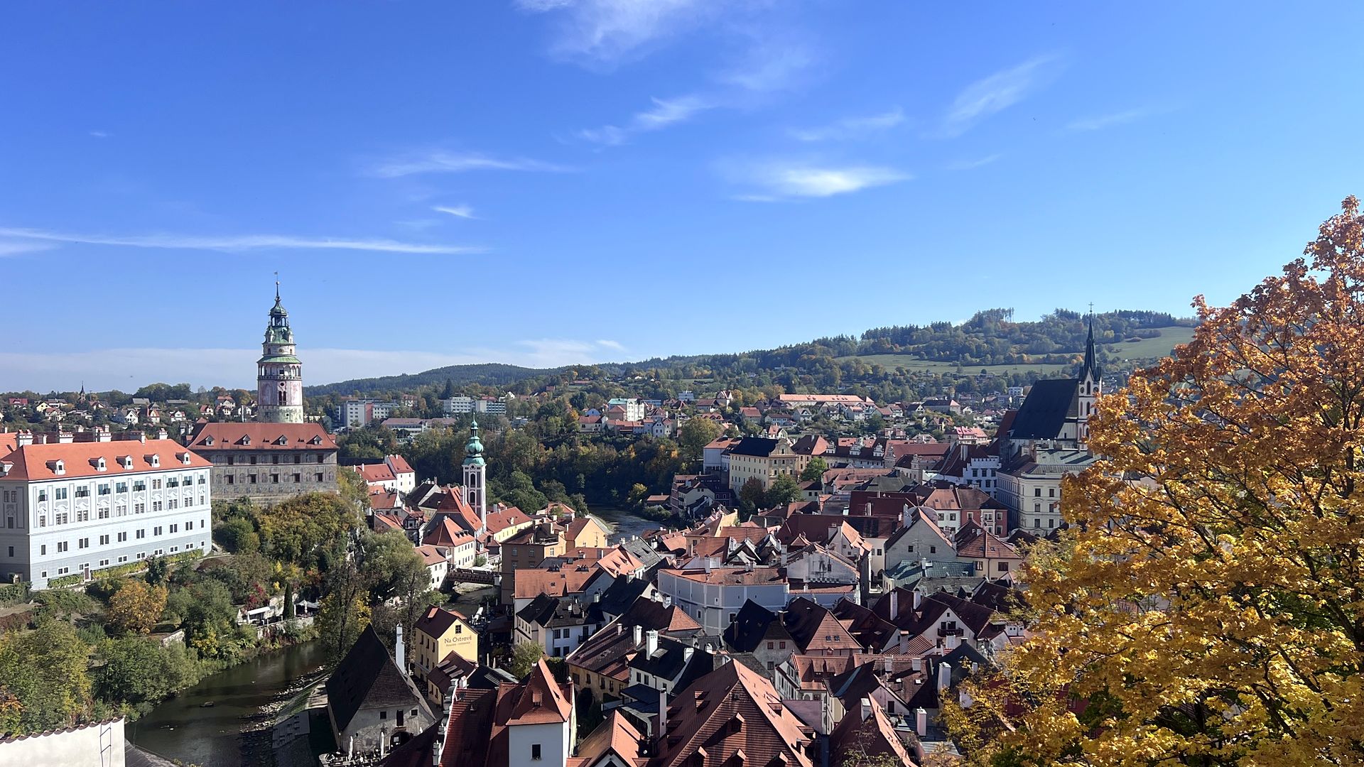 View over the red roofs and river bend of Český Krumlov with the castle tower